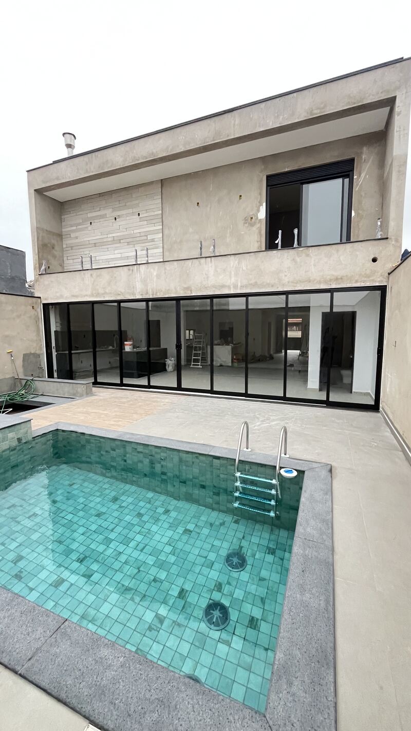 Fachada de residência com área de piscina e esquadrias em alumínio preto