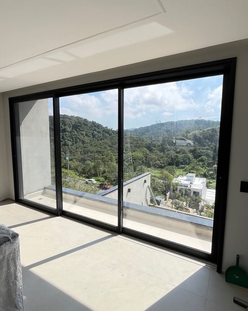Grande vão de vidro com vista aberta para área externa arborizada