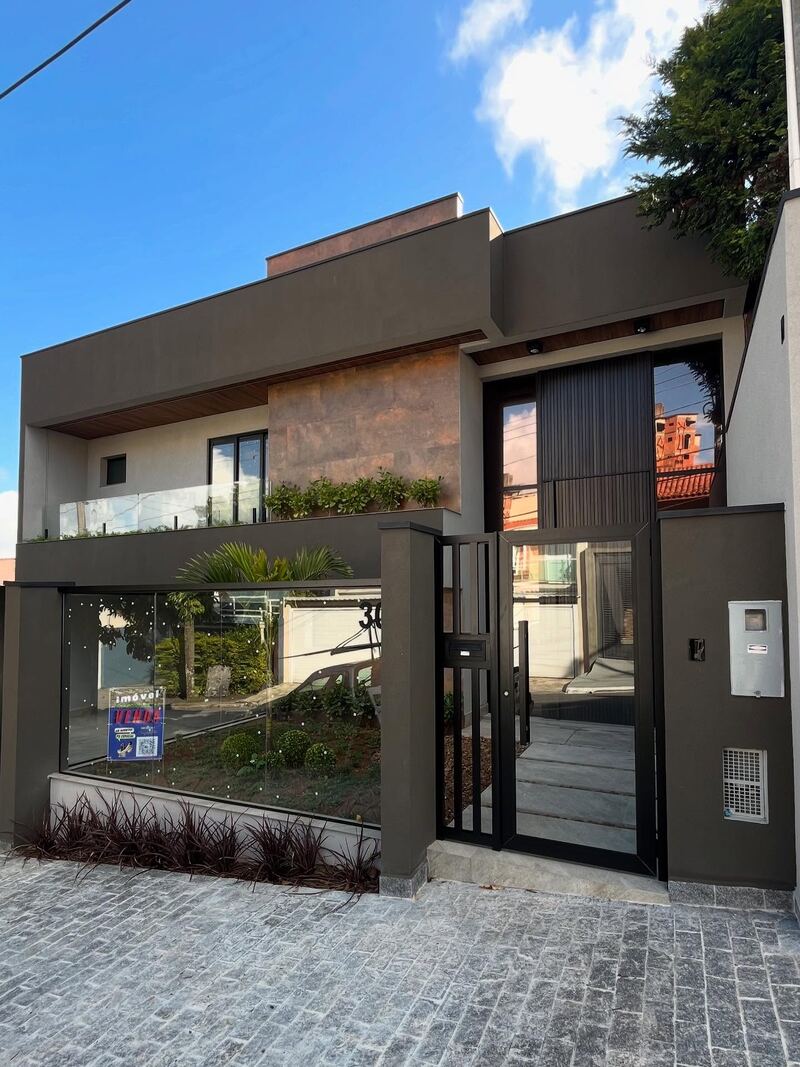 Fachada de sobrado contemporâneo com esquadrias de alumínio preto e vidro